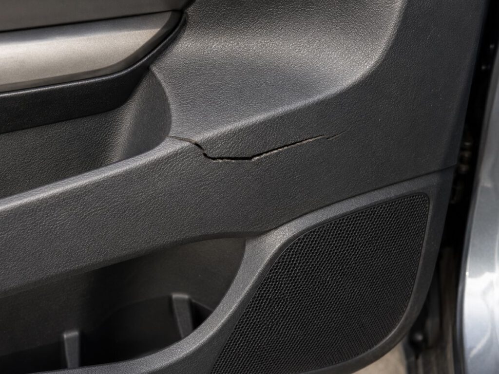 Beschädigtes Kunststoffbauteil am Fahrzeug mit Kratzern und Verformungen